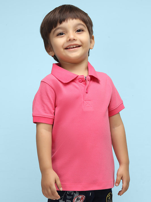 a little boy wearing a bubblegum pink polo t shirt and jeans in standing position