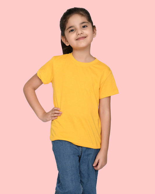 a little girl wearing a nusyl yellow short sleeve t shirt and blue jeans in standing with is hands on his waist
