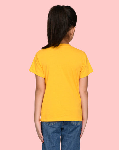 a little girl standing back wearing nusyl yellow short sleeve t shirt with blue jeans